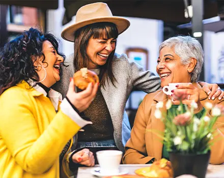 friends at outdoor cafe laughing together successful retirement