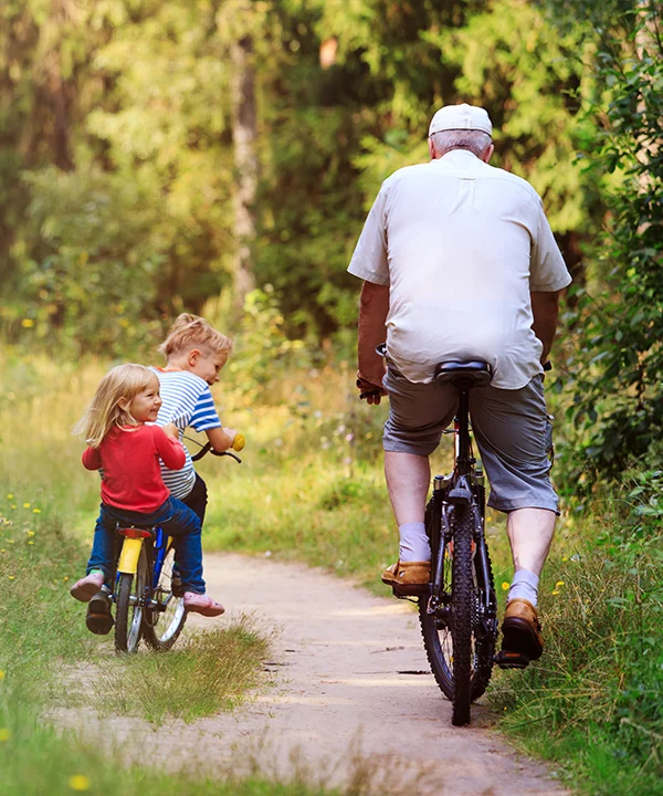 grandkids riding bikes with their grandfather